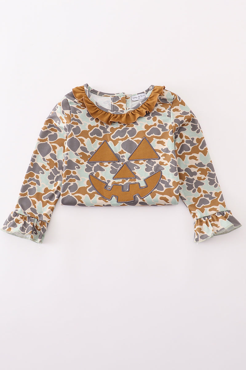 Close-up of pumpkin applique on camouflage ruffle dress