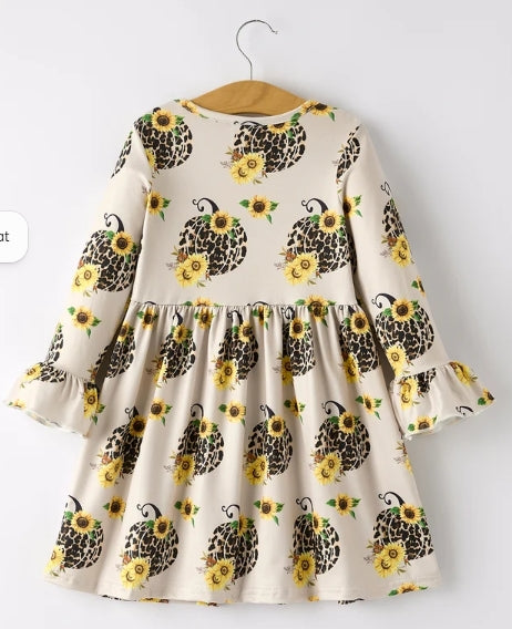 Back of pumpkin and sunflower girls dress with gathered skirt and ruffled cuffs.