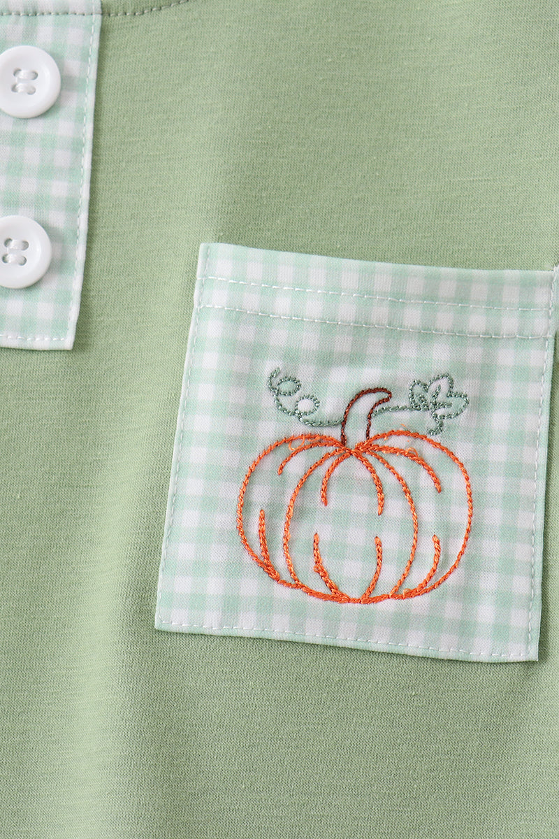Close-up of embroidered pumpkin pocket detail on sage top