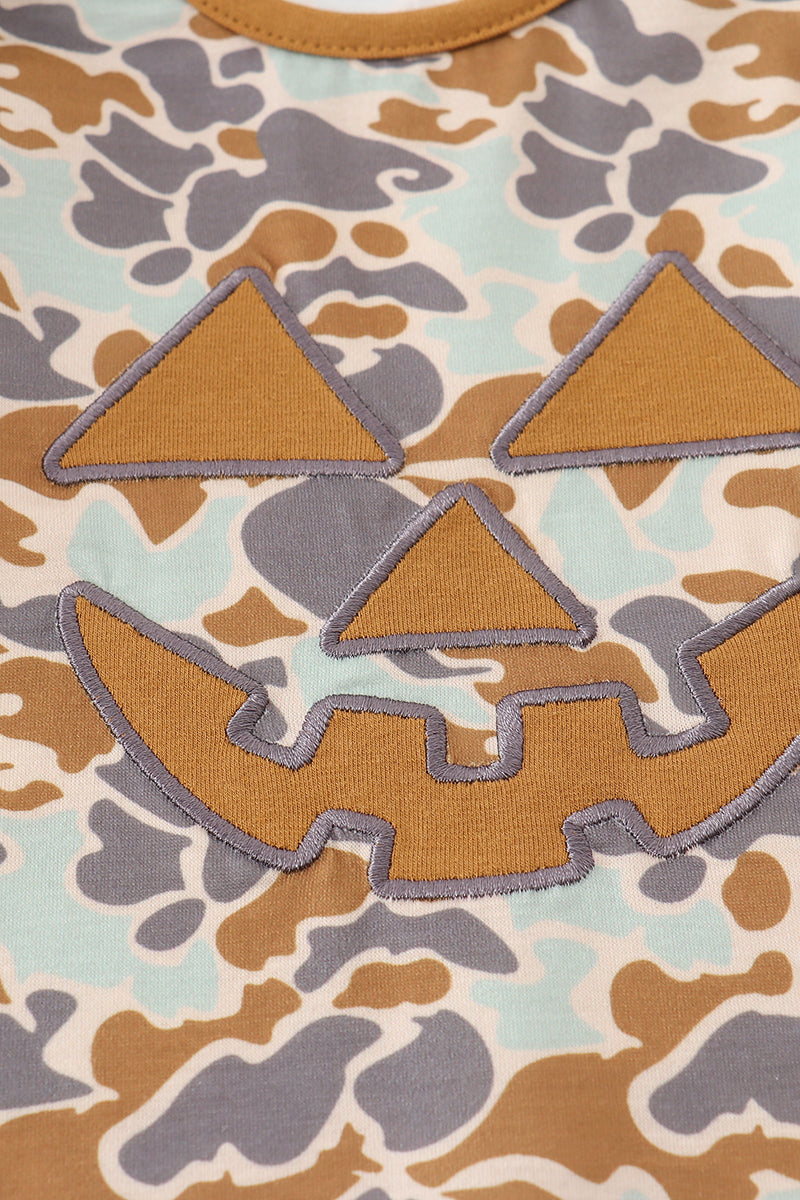 Close-up of pumpkin applique on Halloween camouflage top