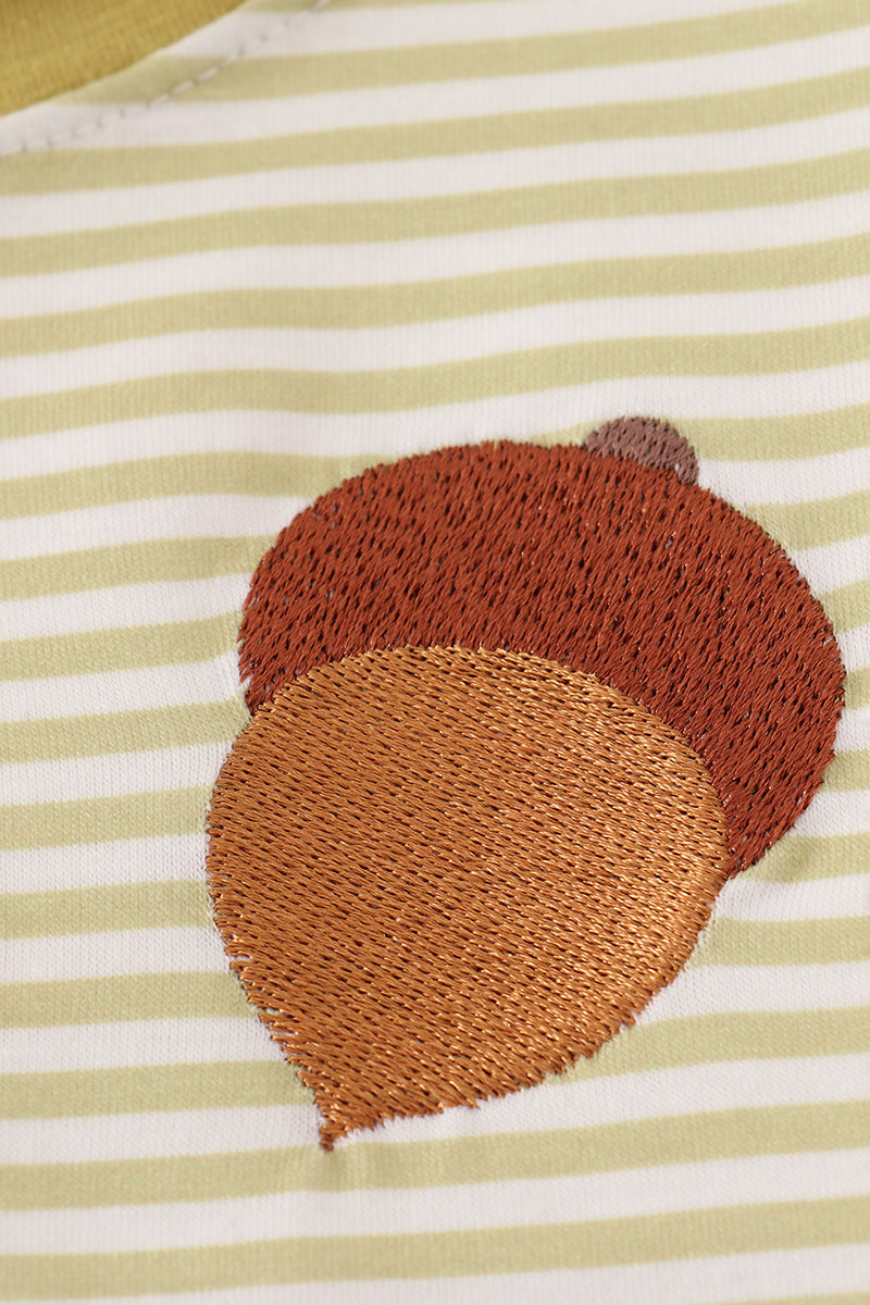 Close-up of pinecone embroidery on striped green top