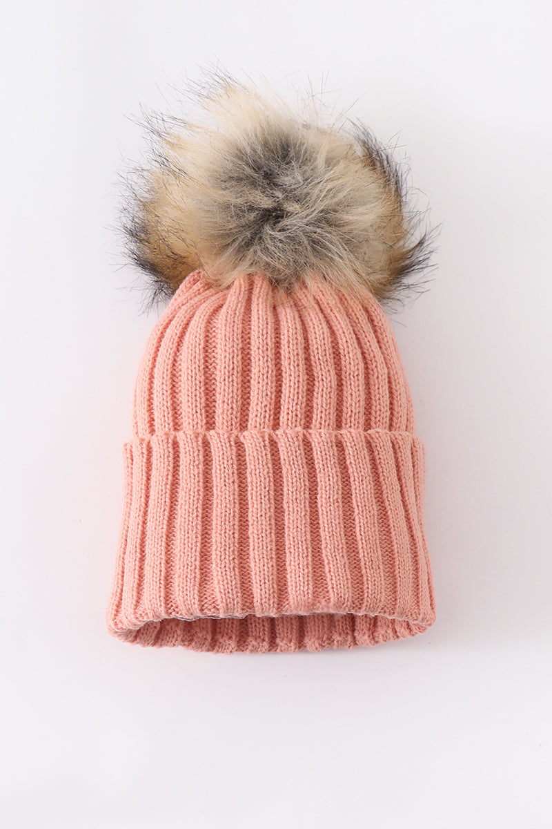 Coral pink knit beanie hat with a fluffy pom pom