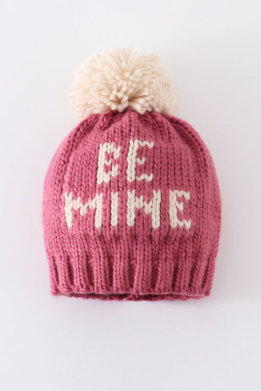 Pink knit beanie with a cream pompom and white BE MINE lettering for kids