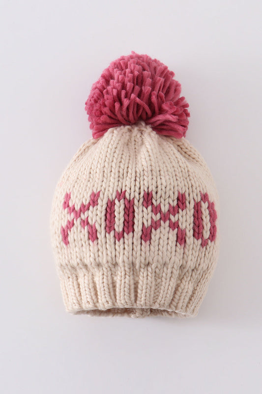 Cream knit beanie with a pink pompom and pink XOXO detail for infants