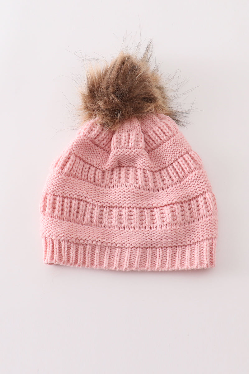 Pink adult cable-knit beanie hat with a fluffy brown pompom, front view