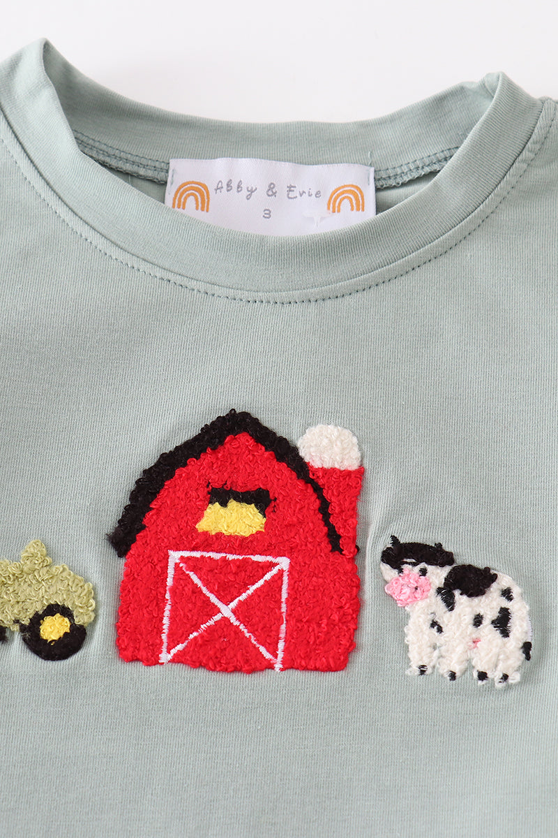 Close-up of French knot farm animal embroidery on green top