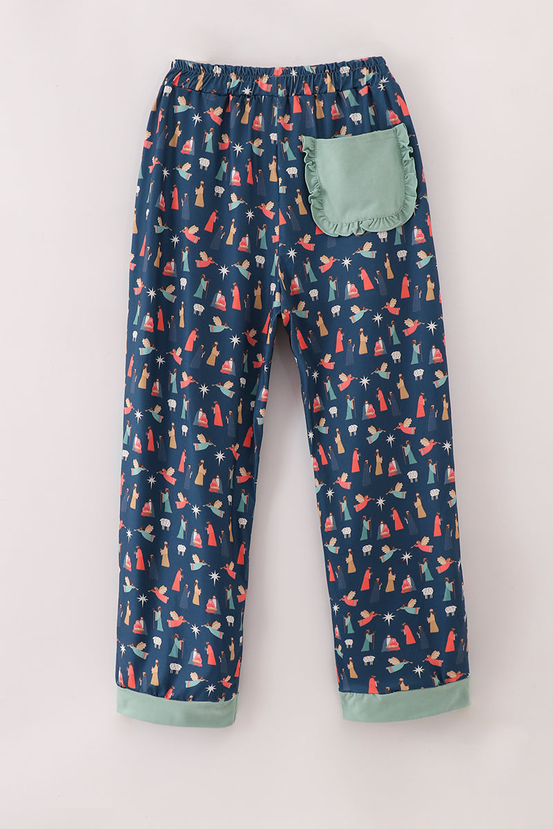 Full-length navy women's Nativity-print pajama pants with mint-green cuffs and a ruffle-trimmed back pocket