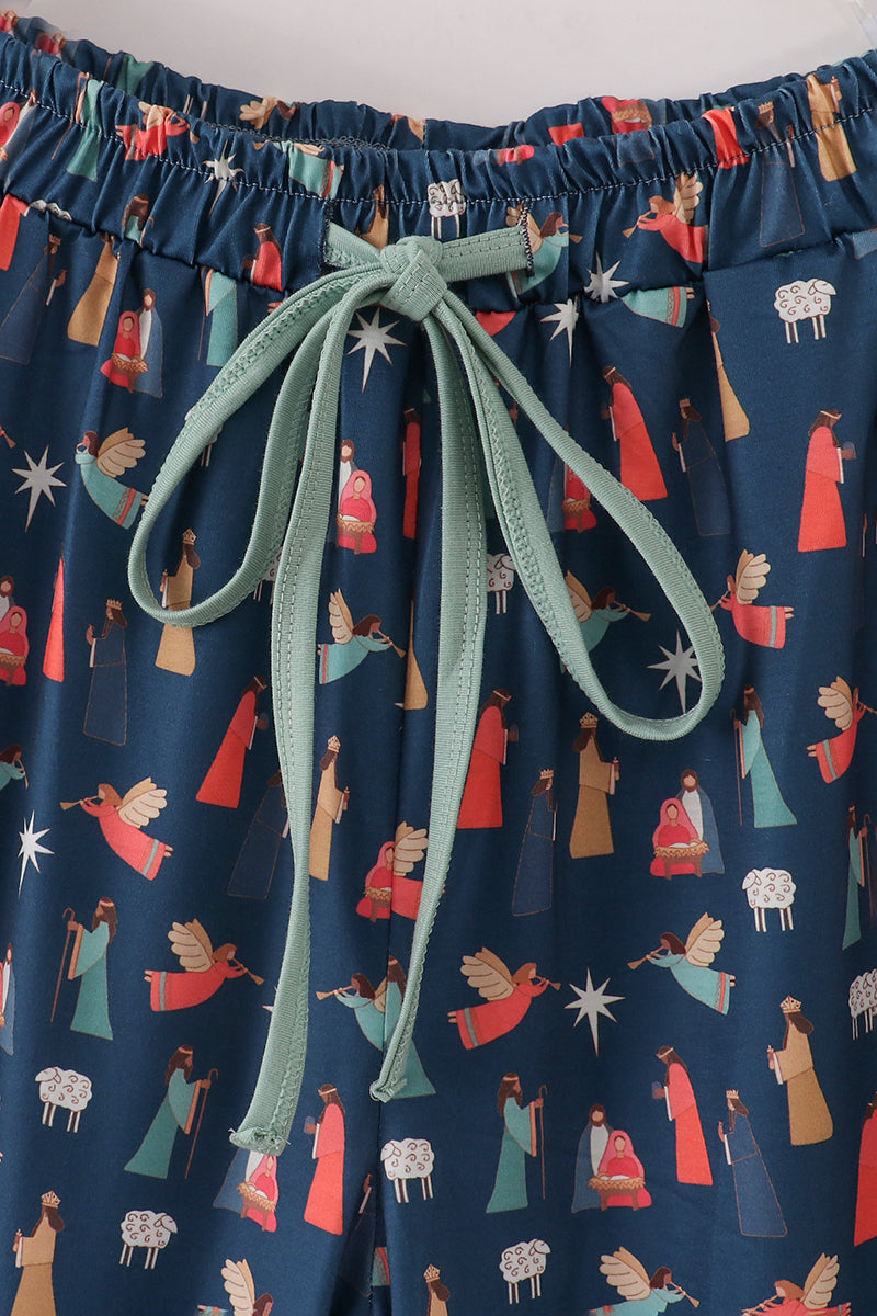 Elastic waistband and mint-green drawstring on navy Nativity-print pajama pants