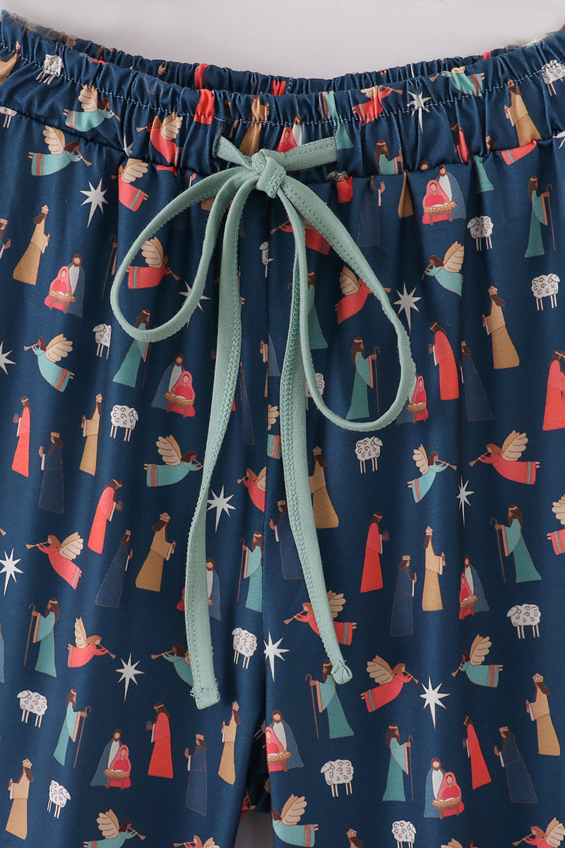 Elastic waistband and mint-green drawstring on navy Nativity-print pajama pants