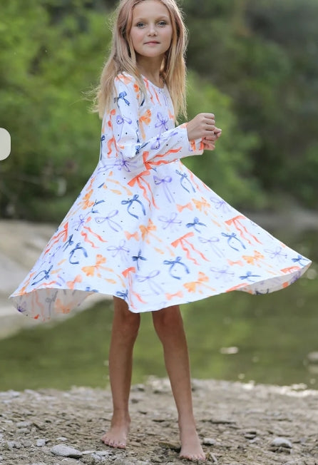 Child modeling the Halloween Bow girls dress outdoors with the skirt extended.