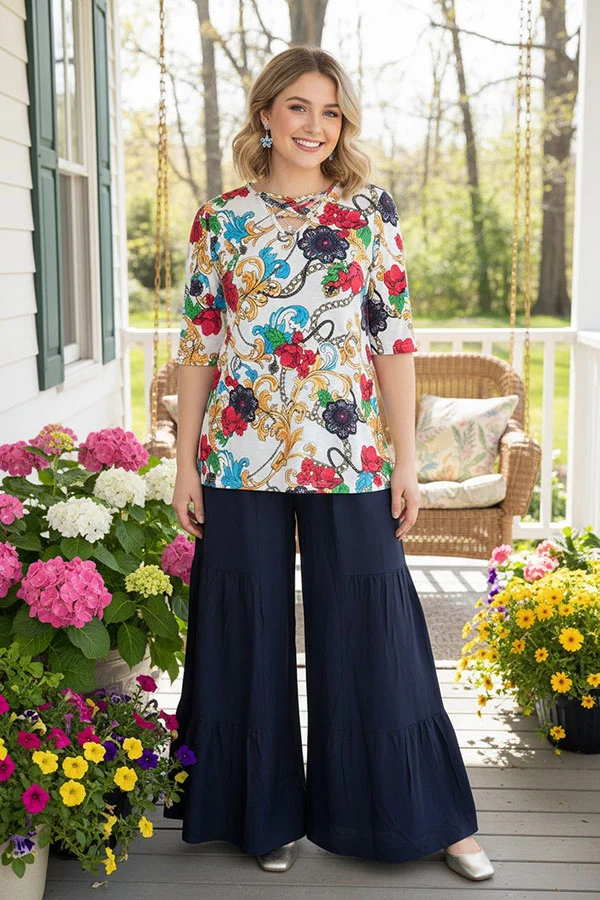 Woman wearing a colorful paisley and floral half-sleeve top with crossed V-neckline.