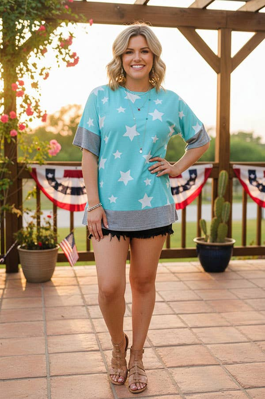 Woman modeling a turquoise white star short-sleeve top with gray sleeve bands and hem trim.