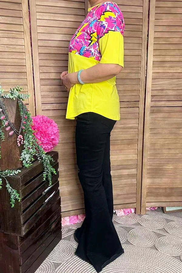 Side view of women's yellow lightning-print short-sleeve top with curved hem.