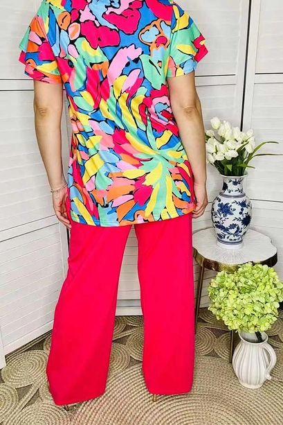 Back view of multicolor floral shirt and red wide-leg pants