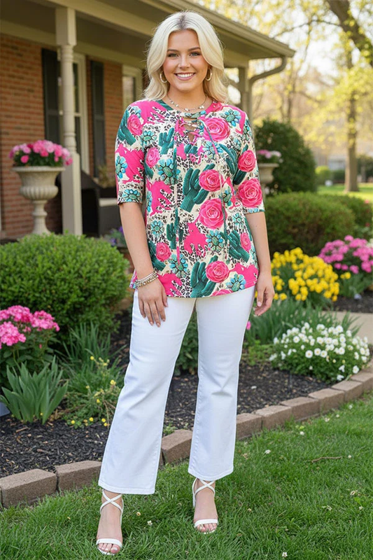 Woman modeling a colorful floral and cactus top with crisscross neckline.