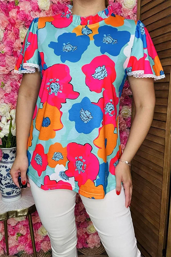 Front detail of floral women's top with ruffled high neckline and white lace sleeve trim.