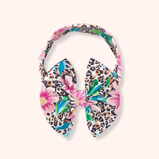 Pete & Lucy Leopard Lagoon bow headband with leopard spots, pink flowers, and teal and green leaves.