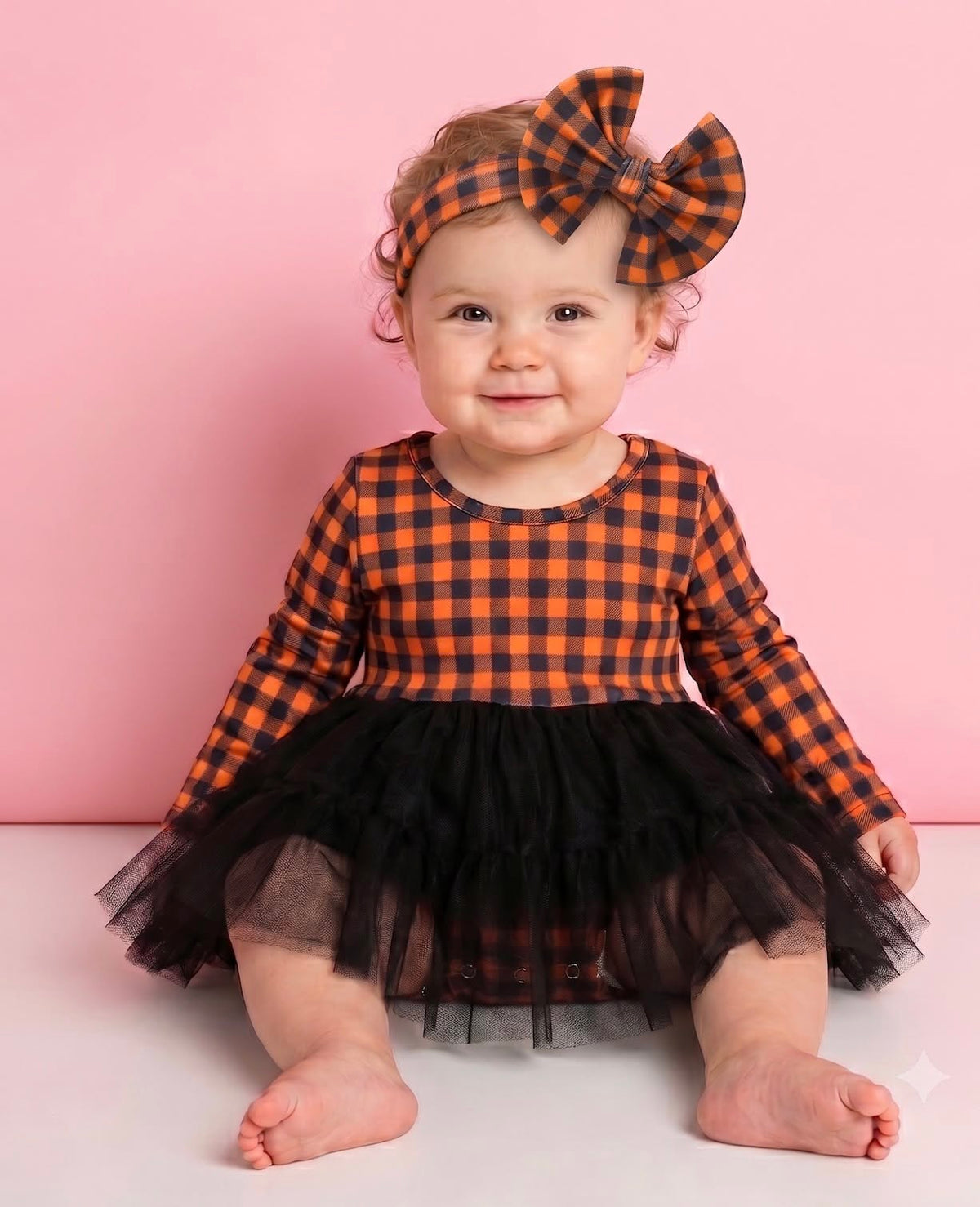 Child wearing the orange-and-black Harvest Gingham bow headband