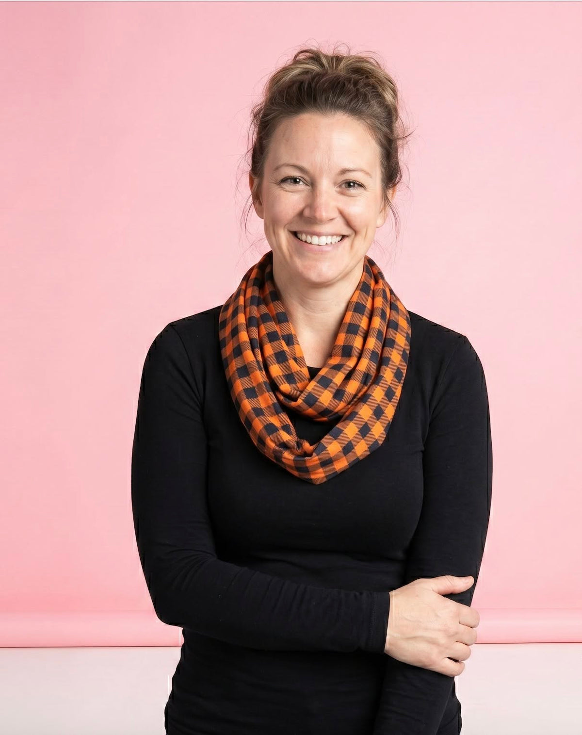 Mom wearing the orange-and-black Harvest Gingham loop scarf